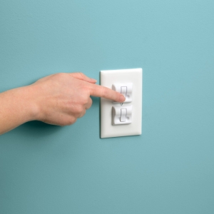 Parent demonstrating the locking function on a wall switch